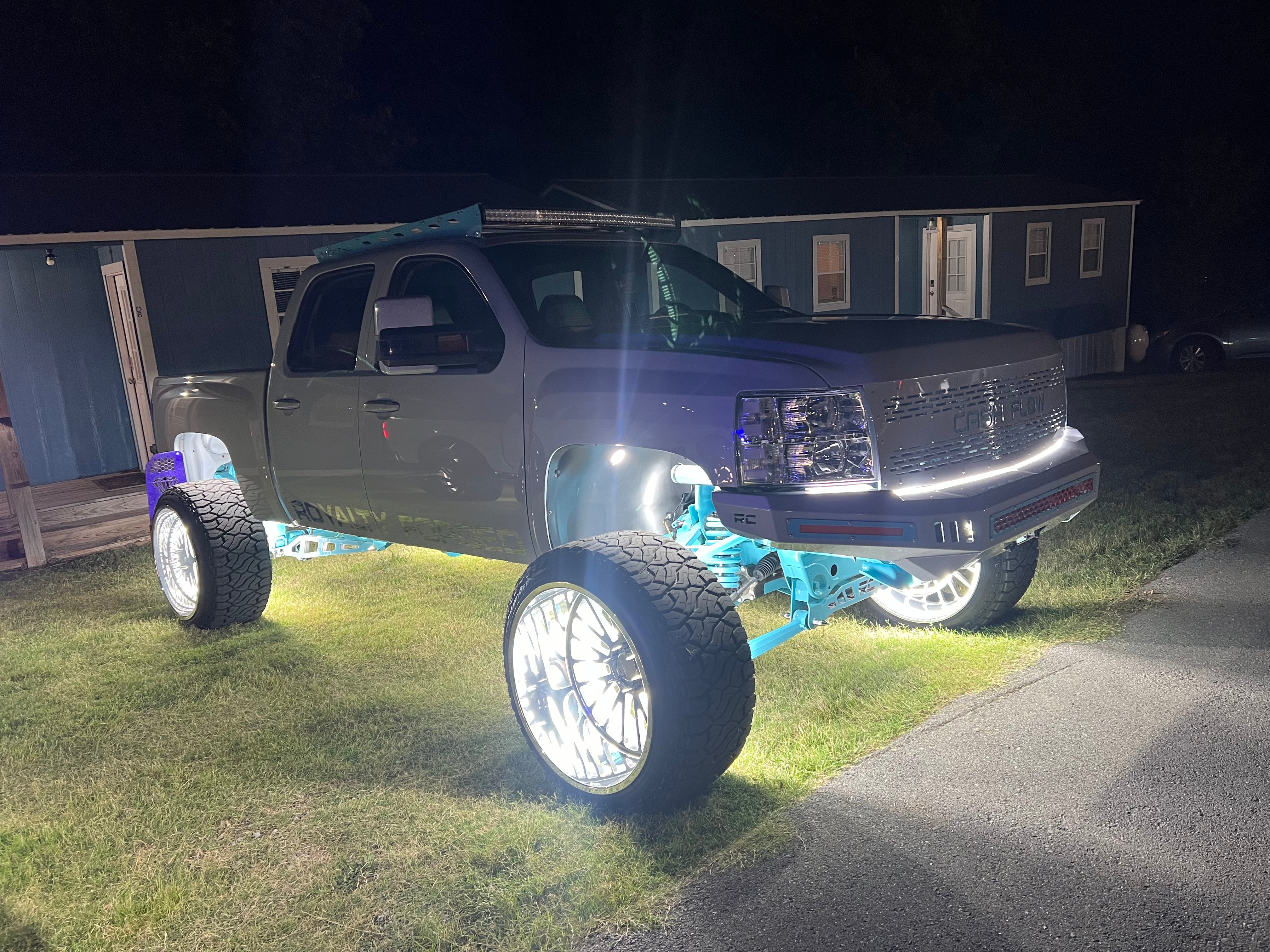 A lifted truck with illuminated wheels and underbody, featured by Maxxed Customs